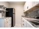 Well-appointed kitchenette featuring stainless refrigerator, open shelving, modern countertops, and white cabinetry at 2563 Coral Ave, Kissimmee, FL 34741