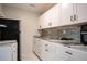 Modern kitchenette with white cabinetry, marble countertops, updated appliances, and subway tile backsplash at 2563 Coral Ave, Kissimmee, FL 34741