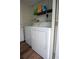 Bright laundry area featuring a white washer and dryer with overhead shelving at 2563 Coral Ave, Kissimmee, FL 34741