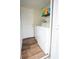 Laundry room with wood floors, appliances, a door, and supplies on a shelf at 2563 Coral Ave, Kissimmee, FL 34741