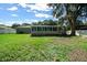 A spacious backyard with a white fence, lush green lawn, screened in back porch, and mature trees at 26 Hemlock Terrace Dr, Ocala, FL 34472