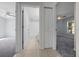 Hallway featuring tile flooring, a bathroom, and a bedroom with carpet flooring at 26 Hemlock Terrace Dr, Ocala, FL 34472