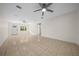 Bright living room with tile flooring, a ceiling fan, and a door leading to the entryway at 26 Hemlock Terrace Dr, Ocala, FL 34472