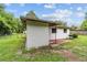 Side view of a white stucco home with a charcoal grill, and a green, grassy backyard at 2602 Ne 2Nd Ave, Ocala, FL 34470