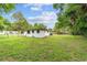 This home features a big backyard with a white stucco exterior, and a charcoal grill at 2602 Ne 2Nd Ave, Ocala, FL 34470