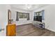 Bright bedroom with hardwood floors, two windows, ceiling fan, and a gray media console at 2602 Ne 2Nd Ave, Ocala, FL 34470