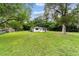Exterior view of the home showing the large, well-maintained lawn and established trees at 2602 Ne 2Nd Ave, Ocala, FL 34470