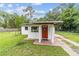 Charming single-story home featuring a red door, stucco siding, and a well-maintained front lawn at 2602 Ne 2Nd Ave, Ocala, FL 34470