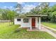 Charming single-story home featuring a red door, stucco siding, and a well-maintained front lawn at 2602 Ne 2Nd Ave, Ocala, FL 34470