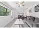 Open-concept living room with tile flooring, gray furniture, and plenty of natural light from the large window at 2602 Ne 2Nd Ave, Ocala, FL 34470