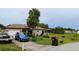 Home exterior featuring a well-maintained lawn, palm trees, and modern solar panels at 313 Oak Track Trce, Ocala, FL 34472