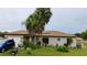 Charming single-story home featuring a well-manicured lawn and mature palm trees at 313 Oak Track Trce, Ocala, FL 34472