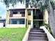 Featuring a two-story facade with balconies, a welcoming entryway, and stairs leading up, it is surrounded by lush greenery at 3525 E Fort King St # 140, Ocala, FL 34470