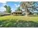 A sprawling backyard featuring the home's yellow exterior, a cozy screened porch and plenty of room for activities at 3831 Se 48Th St, Ocala, FL 34480
