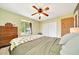 Bedroom with a ceiling fan, wood floors and large window overlooking backyard at 3831 Se 48Th St, Ocala, FL 34480