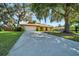 Front of a well-kept home with an attached garage and a lush green lawn surrounded by mature trees, creating curb appeal at 3831 Se 48Th St, Ocala, FL 34480
