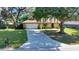 Charming home with an attached garage and a long driveway surrounded by a well-manicured lawn and mature trees at 3831 Se 48Th St, Ocala, FL 34480