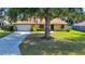 Charming home featuring stone accents and a long driveway framed by mature trees and lush greenery, creating an inviting curb appeal at 3831 Se 48Th St, Ocala, FL 34480