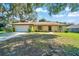 Charming single-story home featuring a manicured lawn, attached garage, and a welcoming stone facade at 3831 Se 48Th St, Ocala, FL 34480