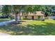 Inviting exterior of home with mature trees, a long driveway, and a well-maintained lawn, offering a warm welcome at 3831 Se 48Th St, Ocala, FL 34480