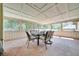 Enclosed porch with a ceiling grid, neutral colored walls, and views of the surrounding greenery at 3831 Se 48Th St, Ocala, FL 34480