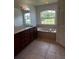 Bathroom featuring a double vanity, soaking tub, and a view of the backyard at 3858 Sw 161St St, Ocala, FL 34473