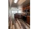 Well-lit kitchen boasts stainless steel appliances, wood cabinets and stylish wood flooring at 3858 Sw 161St St, Ocala, FL 34473