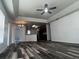 Bright living room with modern ceiling fan and wood flooring that flows into the kitchen at 3858 Sw 161St St, Ocala, FL 34473