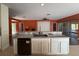 Kitchen island featuring granite countertop, white cabinetry, black dishwasher, and an open view to the living area at 3950 Sw 54Th Ct, Ocala, FL 34474