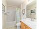Bright bathroom featuring a shower-tub combo, tile flooring, and wood vanity at 4094 Sw 51St Ct, Ocala, FL 34474
