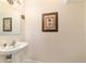 Charming half bathroom with pedestal sink and decorative mirror at 4094 Sw 51St Ct, Ocala, FL 34474