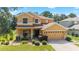 Inviting two-story home featuring manicured lawn, tidy shrubbery, and neutral stucco exterior with an attached two car garage at 4094 Sw 51St Ct, Ocala, FL 34474