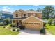 Inviting two-story home featuring manicured lawn, tidy shrubbery, and neutral stucco exterior with an attached two car garage at 4094 Sw 51St Ct, Ocala, FL 34474