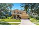 Inviting two-story home featuring manicured lawn, tidy shrubbery, and neutral stucco exterior with an attached two car garage at 4094 Sw 51St Ct, Ocala, FL 34474