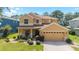 Inviting two-story home featuring manicured lawn, tidy shrubbery, and neutral stucco exterior with an attached two car garage at 4094 Sw 51St Ct, Ocala, FL 34474