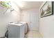 Clean laundry room with front load machines, storage shelf, and tile floor at 4094 Sw 51St Ct, Ocala, FL 34474