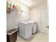 Clean laundry room with front load machines, storage shelf, and tile floor at 4094 Sw 51St Ct, Ocala, FL 34474