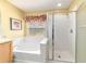 A bright main bathroom showcasing a soaking tub and a glass enclosed shower at 4094 Sw 51St Ct, Ocala, FL 34474