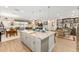 Open-concept kitchen and living area with granite island, wood floors, and view of a covered lanai at 4340 Nw 56Th Ct, Ocala, FL 34482