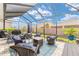 Inviting screened patio featuring comfortable wicker seating, a cozy fire pit, and lush landscaping at 4340 Nw 56Th Ct, Ocala, FL 34482