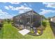 Spacious screened patio surrounded by a manicured lawn and garden, offering privacy and relaxation at 4340 Nw 56Th Ct, Ocala, FL 34482