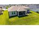 A sprawling backyard with lush green grass features a screened in patio with seating at 4416 Homan Loop, The Villages, FL 32163