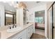 Bathroom featuring double sinks, a walk-in shower and views into the main bedroom at 4416 Homan Loop, The Villages, FL 32163