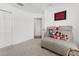 A comfortable gray chaise lounge with decorative pillows and art in the home's bedroom at 4416 Homan Loop, The Villages, FL 32163