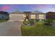 Charming single-story home featuring a well-manicured lawn, lovely landscaping, and an attached two-car garage at 4416 Homan Loop, The Villages, FL 32163