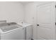 A well-lit laundry room features new, modern, side-by-side washing and drying machines at 4416 Homan Loop, The Villages, FL 32163