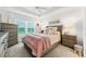 Comfortable main bedroom with tray ceiling, large window, and neutral colors at 4416 Homan Loop, The Villages, FL 32163