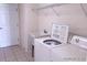 Functional laundry room featuring tile flooring, utility sink, washer, and dryer at 4420 Sw 100Th St, Ocala, FL 34476