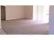 Spacious living room with neutral carpet, sliding glass doors, and ample natural light at 4420 Sw 100Th St, Ocala, FL 34476