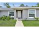Close-up of the home's entrance, featuring a white front door, symmetrical windows, and verdant landscaping at 4501 Sw 159Th Street Rd, Ocala, FL 34473